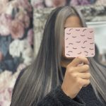 woman holding mirror after haircut